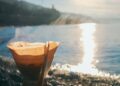 turkish coffee brewing on pebbles and morning sun reflecting in the sea