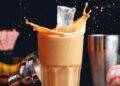 a photo of hand putting ice on a coffee