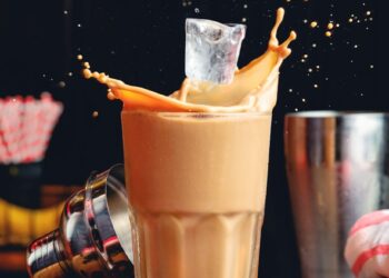 a photo of hand putting ice on a coffee