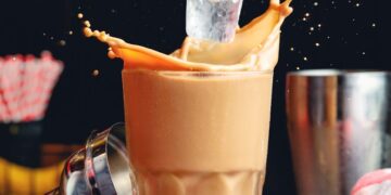 a photo of hand putting ice on a coffee